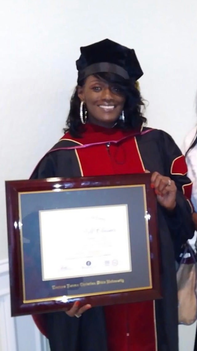 A proud graduate with her framed certificate